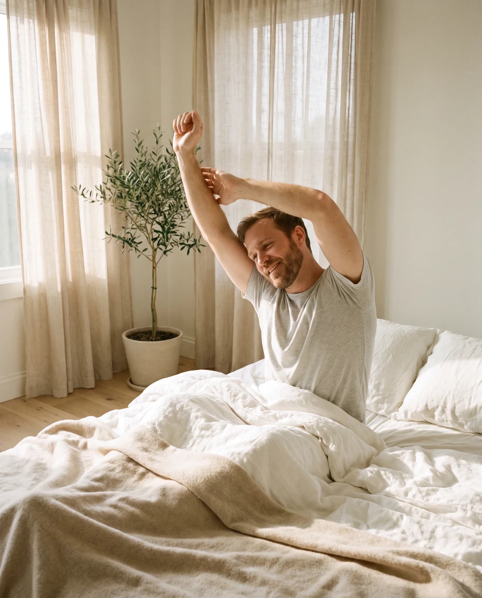 Man waking up refreshed in a bright morning bedroom