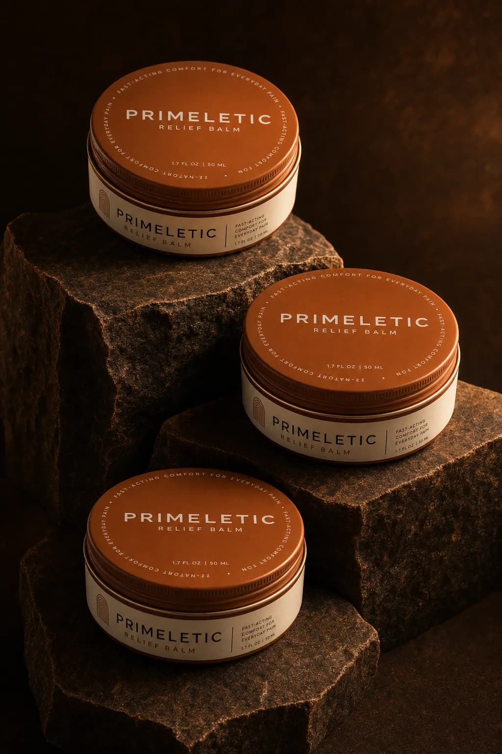 Three sealed tins of Primeletic Relief Balm standing on dark stone
