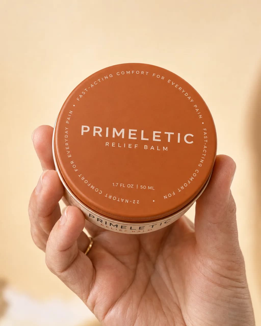 A hand holding out the closed Primeletic Relief Balm tin